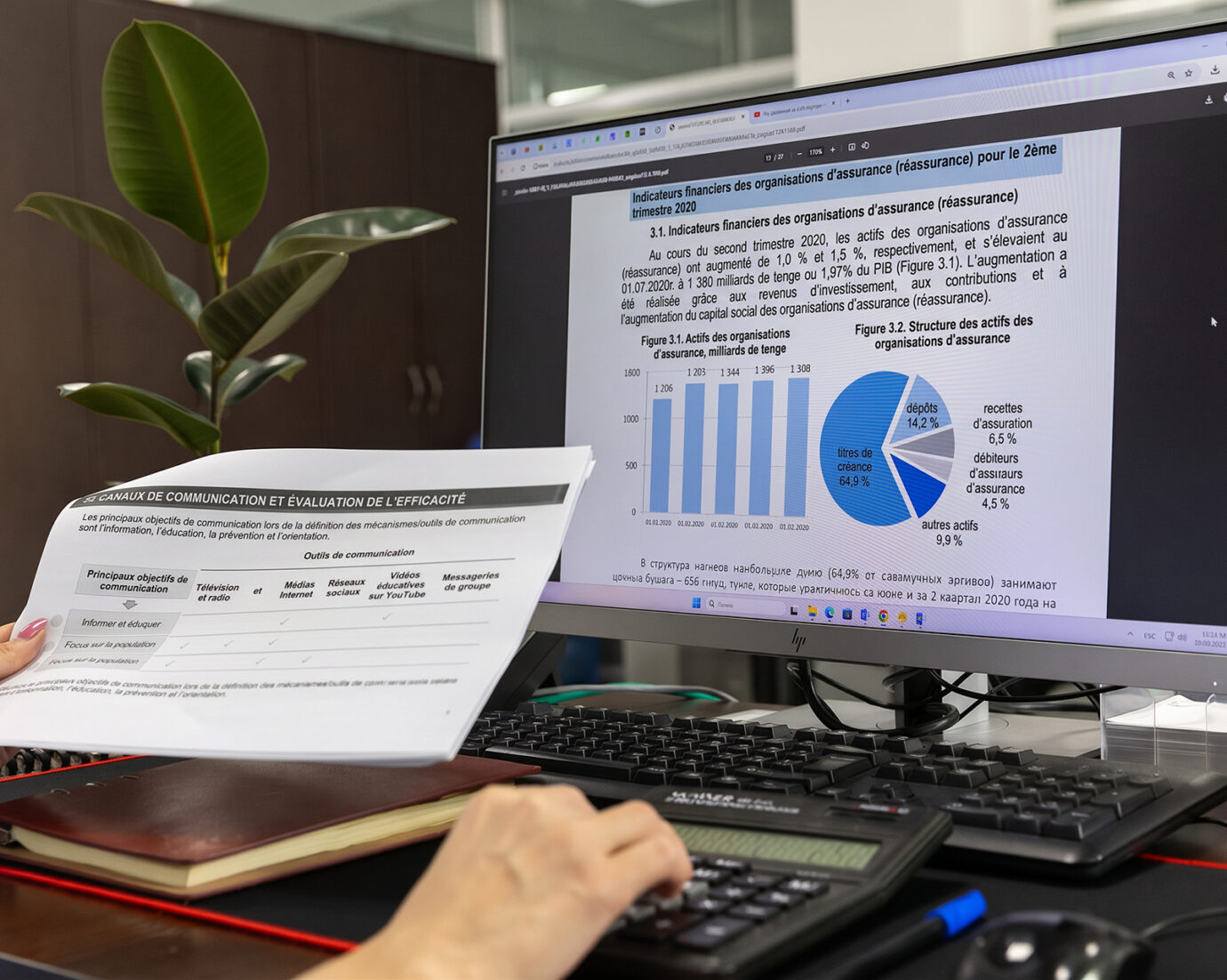 Personne comparant un document imprimé aux graphiques affichés sur son écran